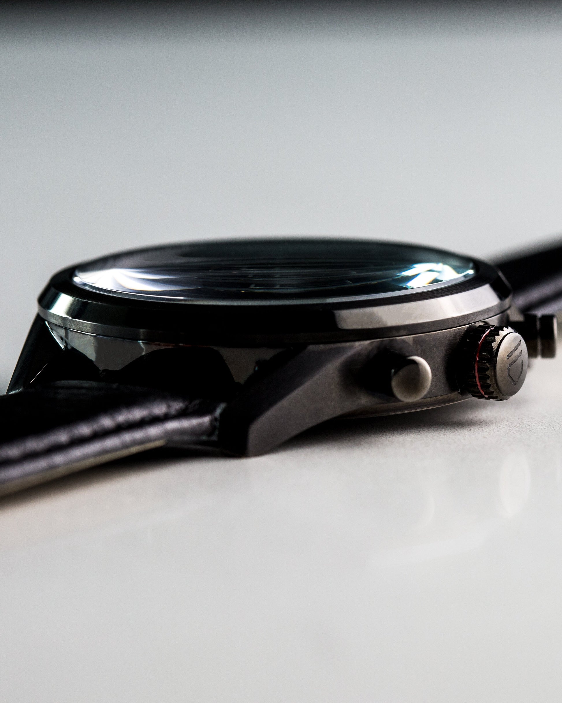 Black watch case showing crown with engraved logo